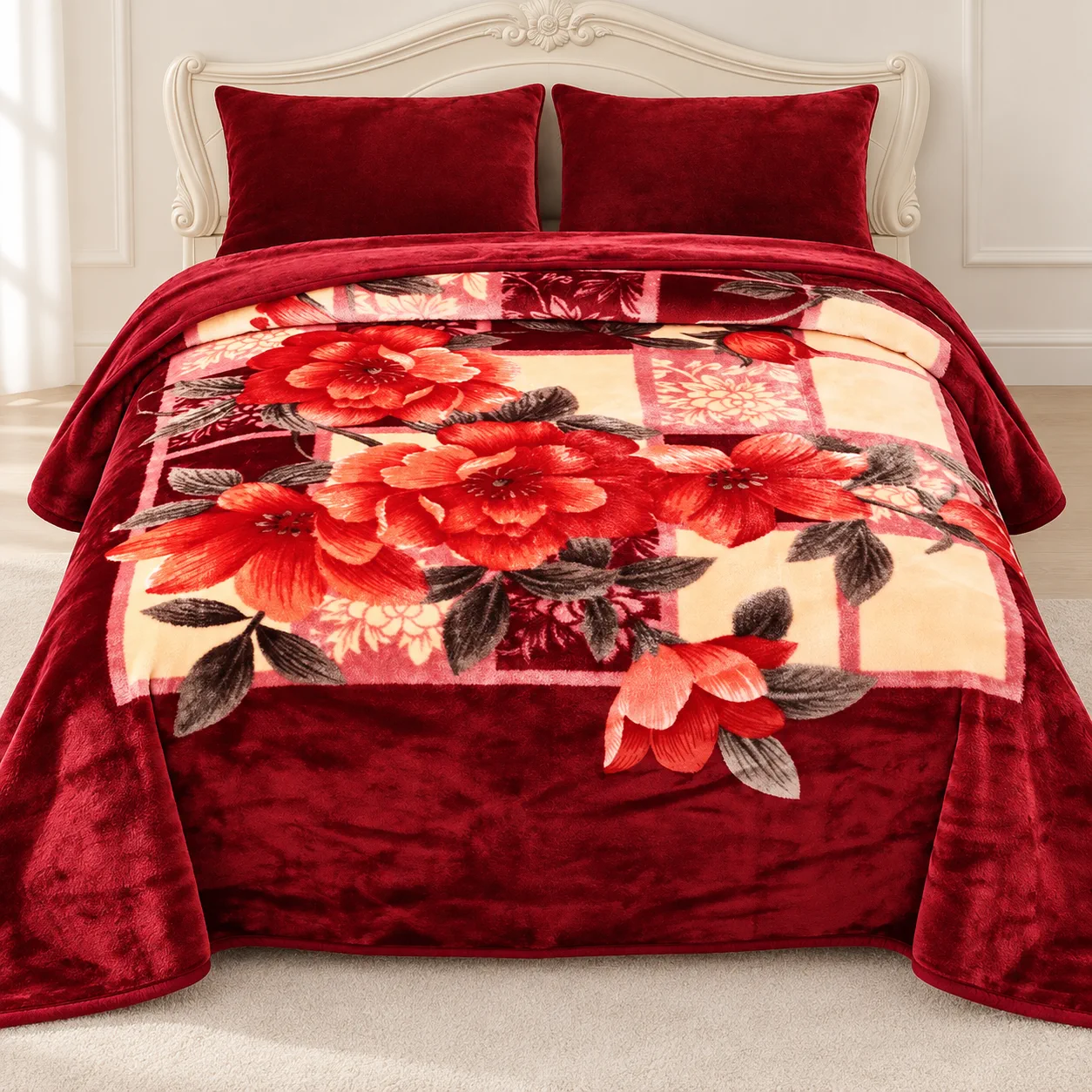 Deep red plush blanket with a rose print on a bed