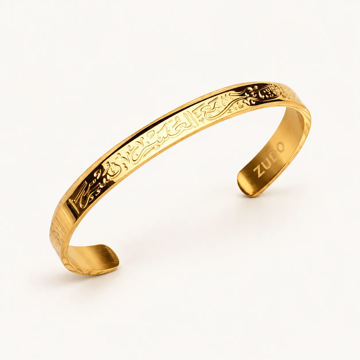 Open gold cuff bracelet engraved with Arabic script